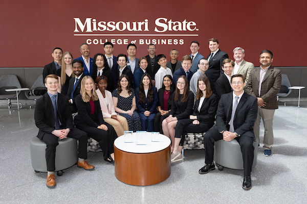 Student members of the Association of Information Technology Professionals gather in a classroom for a photo.